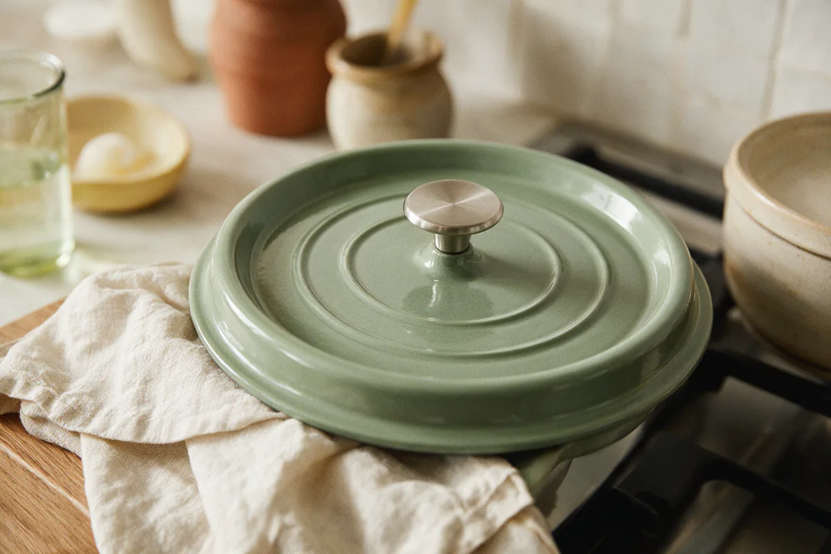 A Dutch oven lid with a stainless steel knob and a heavy, tight-fitting rim.