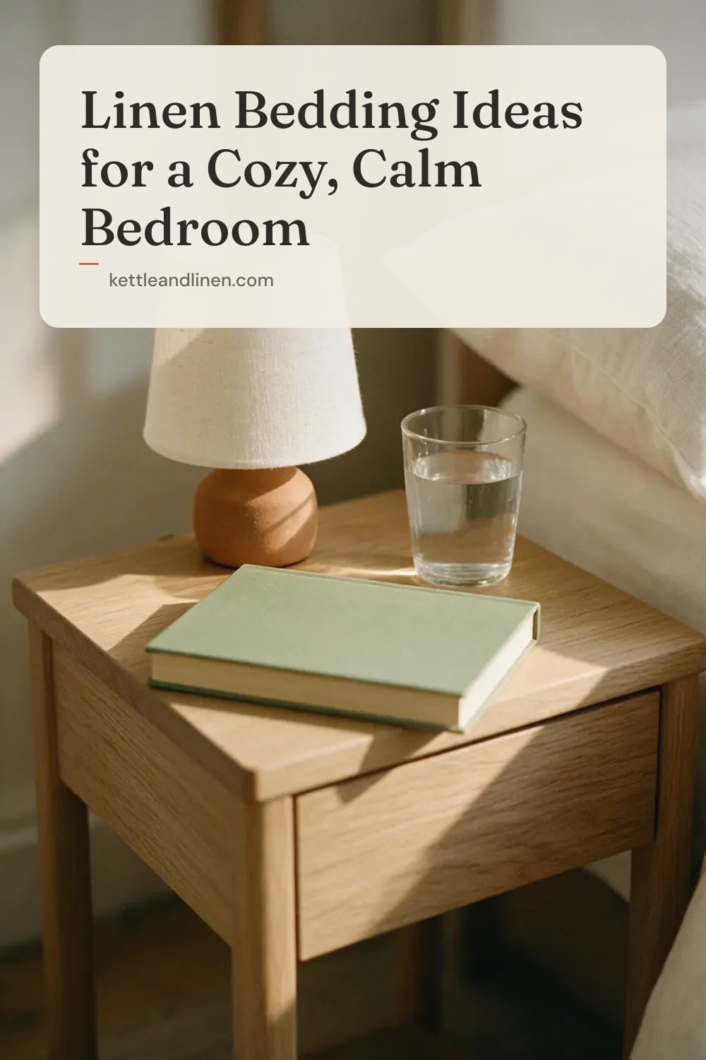 A wooden bedside table with a ceramic lamp, a book and a glass of water.