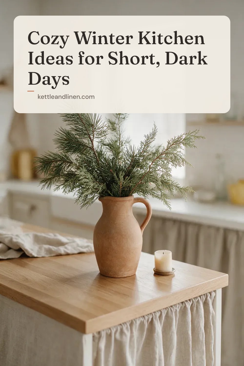 A stoneware jug of fresh pine and cedar branches next to a candle on a kitchen counter.