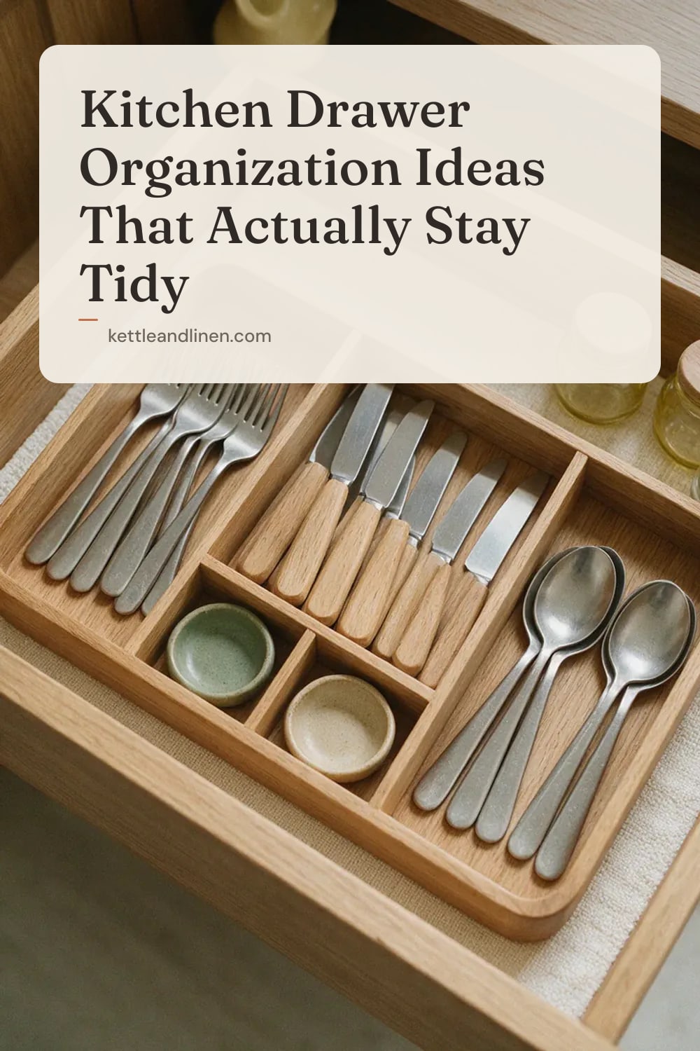 A cutlery drawer from above with a wooden tray and neatly sorted forks, knives and spoons.
