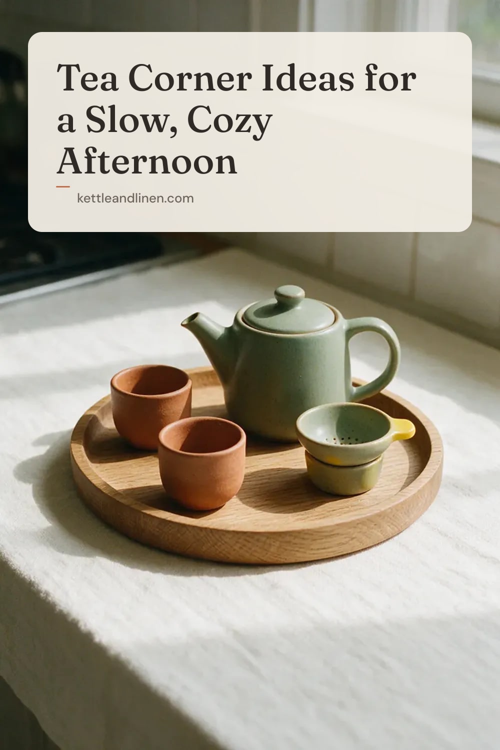A wooden tray with a ceramic teapot, two small cups and a strainer on a counter.