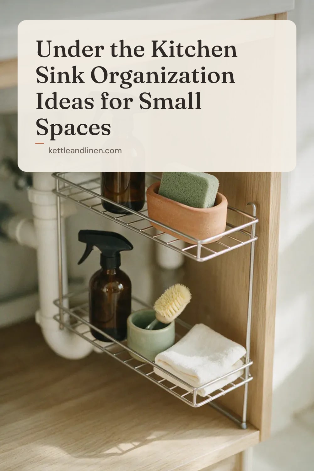 An organized under-sink cabinet with a two-tier shelf fitted around the pipes.